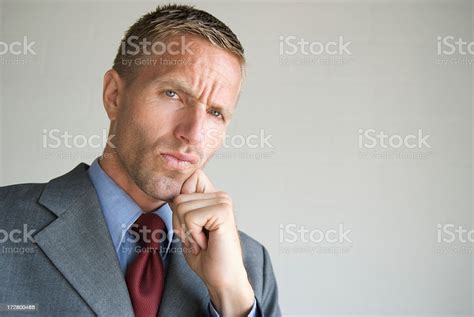 cool young man businessman thinking  hand  chin stock photo