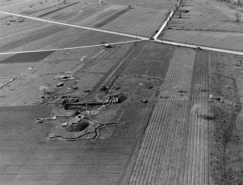 Black And White Photo Of Farm Land With Tractor Tracks
