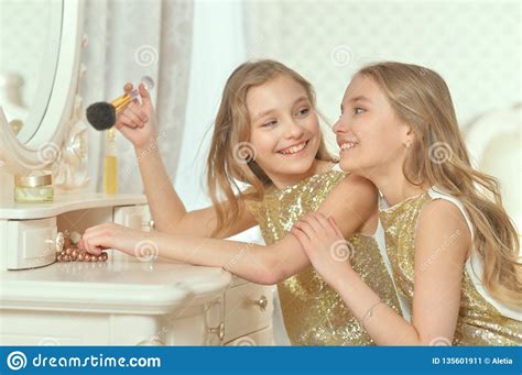 portrait of cute sisters in golden dresses sitting near dressing table stock image image of