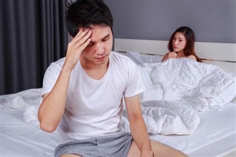 Upset Man Having Problem Sitting On The Bed With His Wife In Bedroom