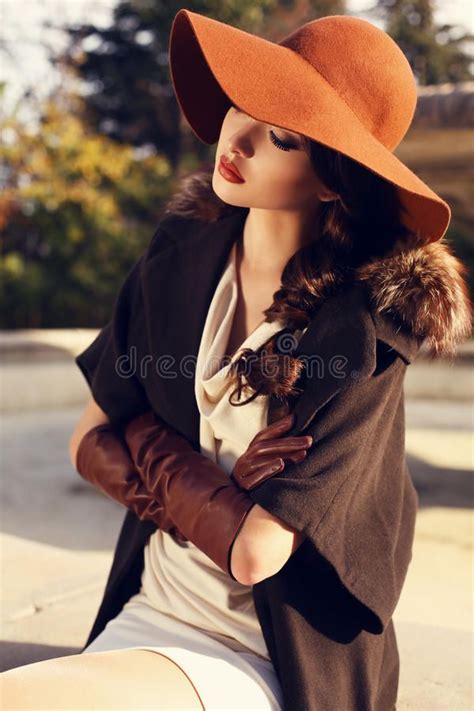 beautiful girl with dark hair wearing elegant coat hat and