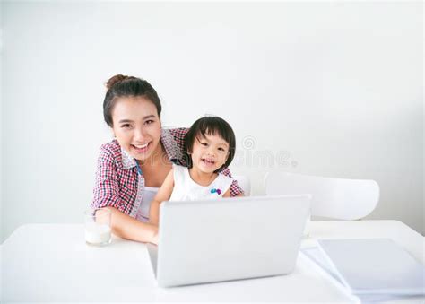 Hispanic Mother And Her Daughter Working On A Computer