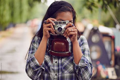 girl taking photo with vintage camera del colaborador de stocksy