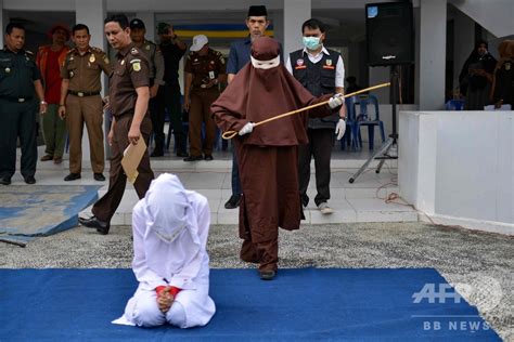 夫ではない男性のそばにいた女性、公開むち打ち刑に インドネシア 写真2枚 国際ニュース：afpbb news
