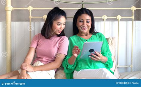 Asian Beautiful Mother And Pretty Teenage Daughter With Tablet Stock