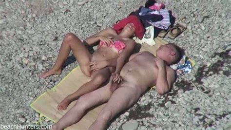 spy cam video of curvy mature chick giving handjob to her hubby on beach