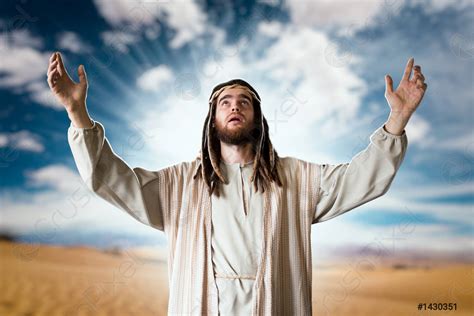 jesus praying   hands   cloudy sky stock photo
