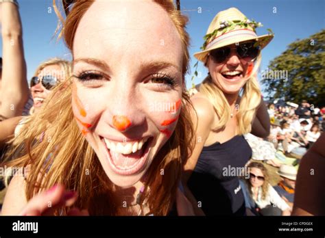 girls laughing and having fun in the sun and a music festival stock