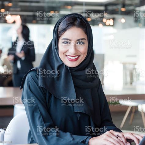 attractive arab businesswoman wearing hijab smiling towards camera