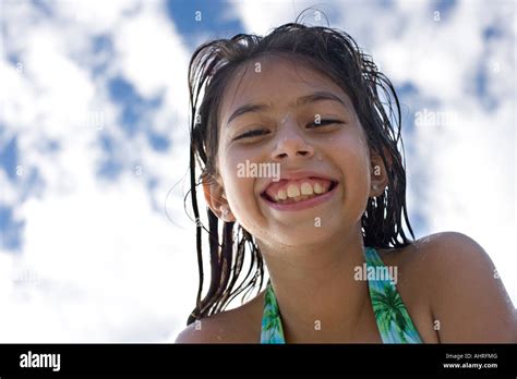hermosa y pequeña niña latina en traje de baño en la piscina fotografía