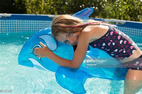 Happy Girl In Swimming Pool With Inflatable Dolphin Photo Getty Images
