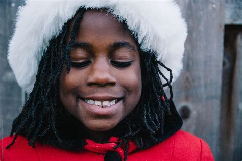 smiling african american girl in festive red coat and santa hat by
