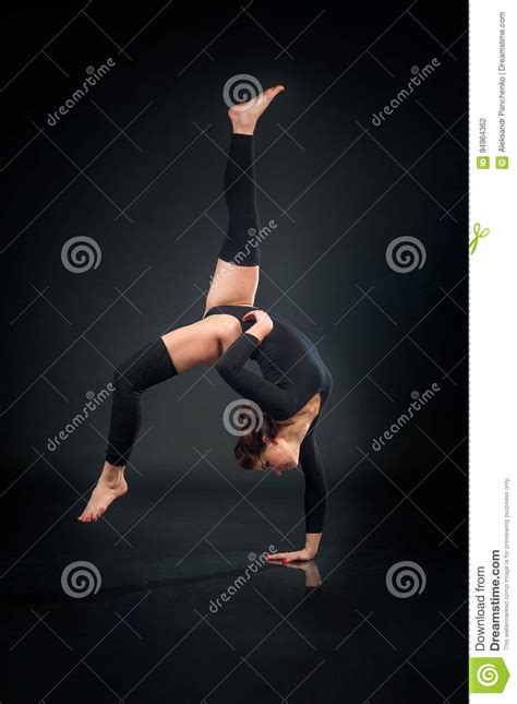 Beautiful Flexible Woman Doing Acrobatic Elements Against Dark B Stock
