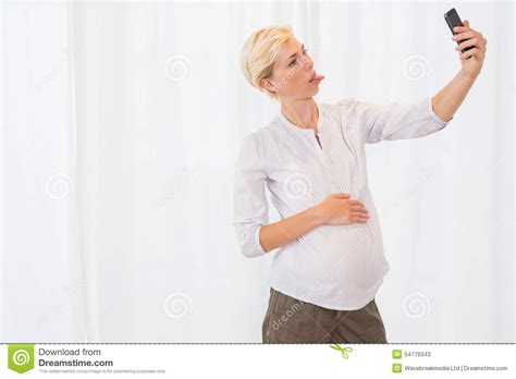 smiling blonde pregnant taking selfie with her mobile stock image image of apartment life
