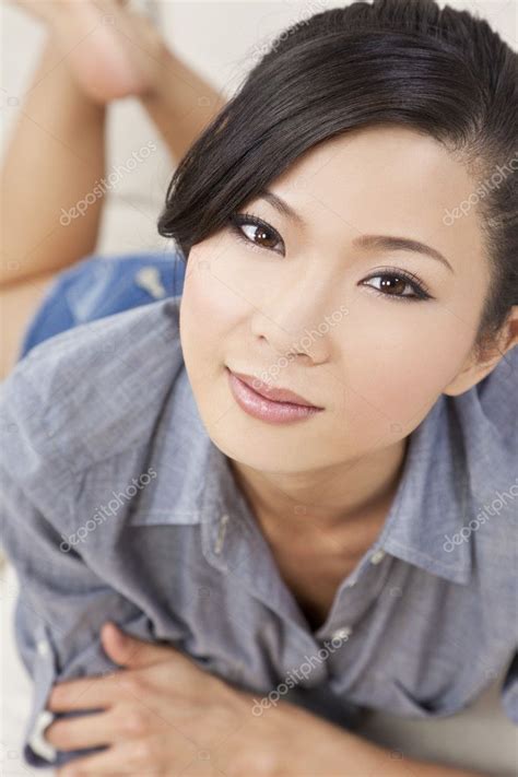 Beautiful Sexy Chinese Asian Woman Laying Down In Denim Shorts Stock