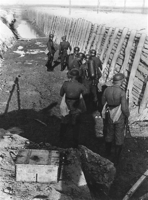 german soldiers walk the length of an anti tank ditch at an undisclosed