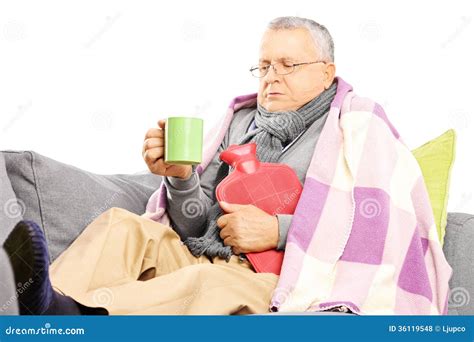 ill middle aged man   sofa covered  blanket drinking hot royalty