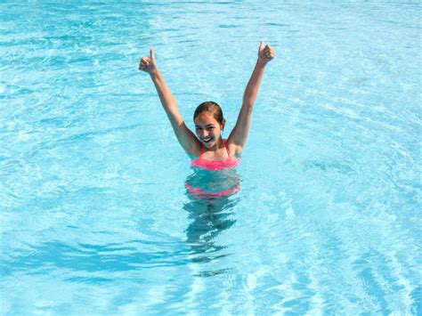 joven adolescente nada y divertirse en la piscina al aire