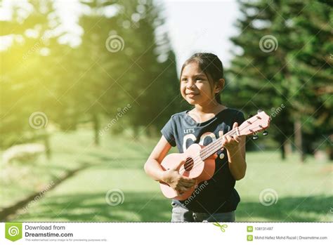 jonge en gelukkige aziatische meisje het spelen ukelele