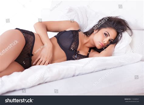 Beautiful Sexy Woman In Black Lingerie Lying On Her Stomach On Her Bed