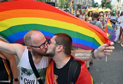 Topshot Participants Kiss Each Other In Front Of A Rainbow Flag As