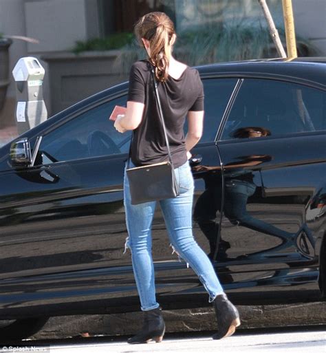 dakota johnson rocks a low key look in ripped jeans and a tee as first footage from fifty