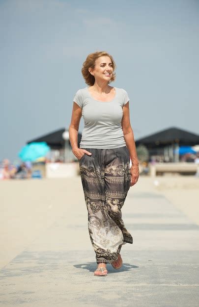 premium photo meautiful older woman walking at the beach
