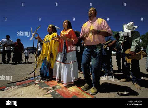 an apache girl dances with her godmother and godfather at her sunrise