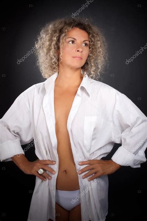 Mature Woman Wearing Man Shirt Against Black Background