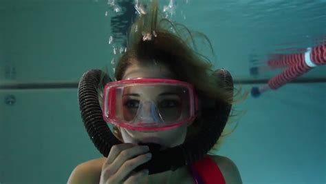 female scuba diver playing with regulator underwater in