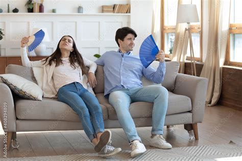 Exhausted Man And Woman Waving Blue Paper Fans Breathing Resting