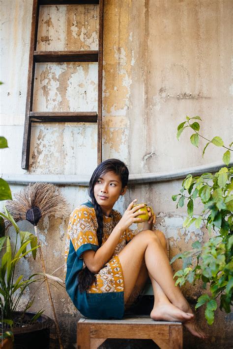 Asian Woman Having Tea Coffee On Balcony By Stocksy Contributor