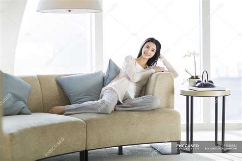 Mujer China Sentada En El Sofá En El Interior De La Sala De Estar
