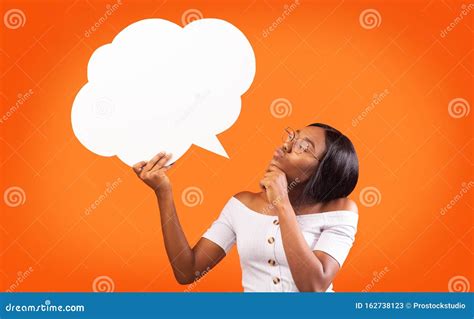 young black woman holding speech bubble standing orange background