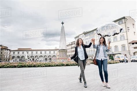 Lesbian Couple Holding Umbrella Fooling Around Holding Hands Smiling