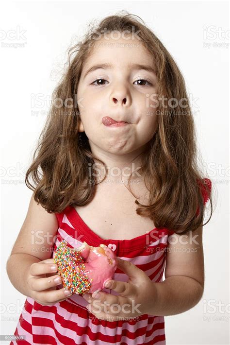 gadis makan donat menjilati bibir foto stok unduh gambar sekarang