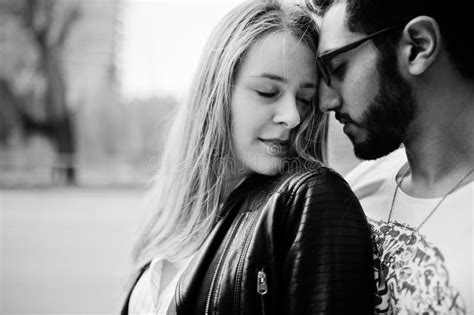 cool multiracial couple posing and hugs together in love stock image