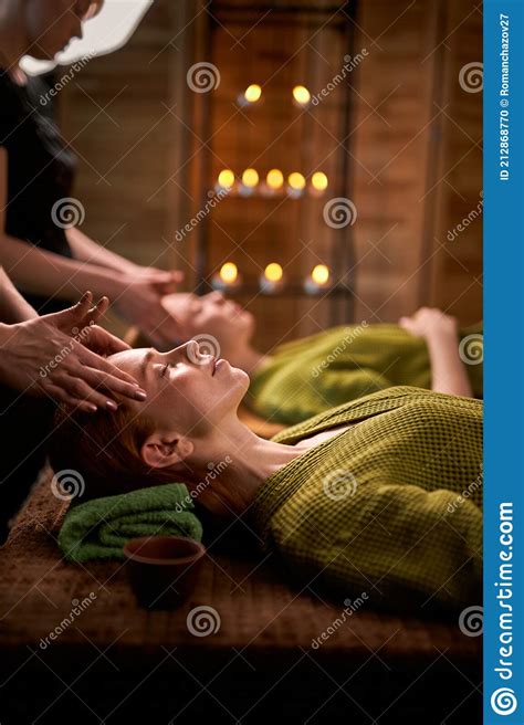 Side View Massage Therapist Gives Head Massage To Redhead Woman Stock