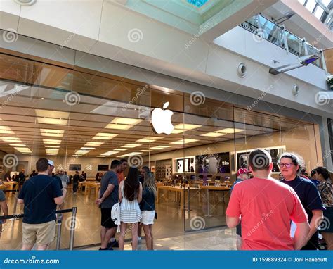 een apple winkel met mensen die wachten om binnen te komen om een apple iphone  te kopen