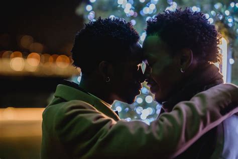 Delicate Black Same Sex Couple Embracing Against Christmas Tree · Free