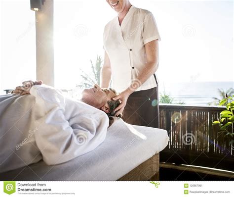 female massage therapist giving a massage at a spa stock