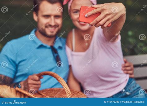 Attractive Happy Couple Taking Selfie At A Picnic In A Park During