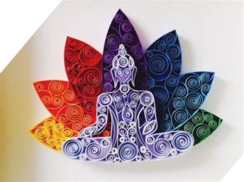 An Origami Buddha Sitting On Top Of A Colorful Flower With Swirls In