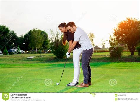 male instructor assisting woman in learning golf royalty free stock image