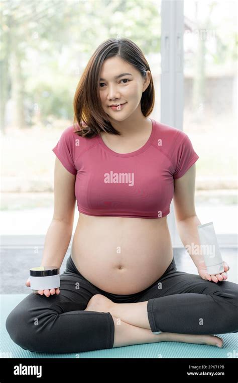Happy Beautiful Young Pregnant Asian Woman In Fitness Clothes Sitting