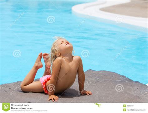 mała dziewczynka na rockowym pobliskim basenie zdjęcie