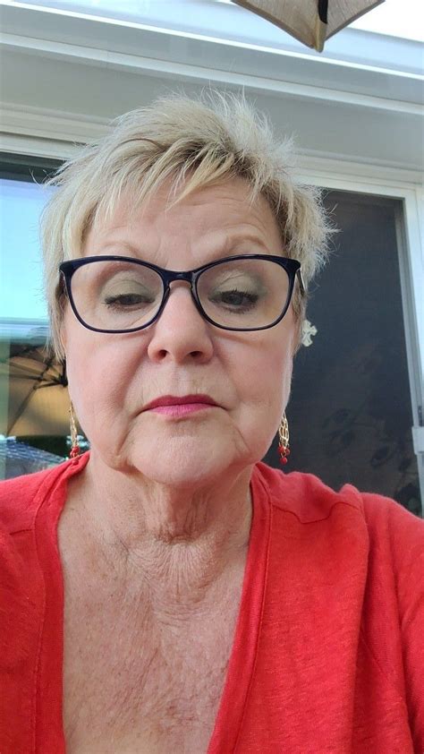 An Older Woman Wearing Glasses Looking At The Camera