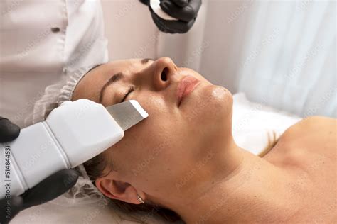 procedure with ultrasonic skin scrubber woman face scrubber treatment