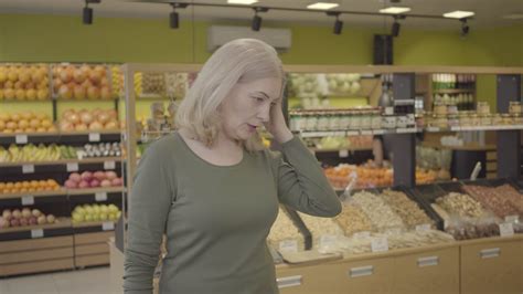 senior caucasian blond woman choosing purchases in grocery portrait of