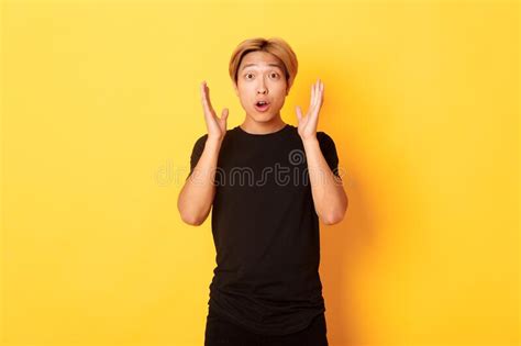 Portrait Of Surprised Gasping Blond Asian Guy Reacting To Awesome News